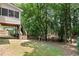 Backyard with deck, stairs, mature trees, natural landscaping, and patio area for outdoor living at 3335 Maple Terrace Dr, Suwanee, GA 30024