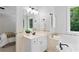 Bright bathroom with a soaking tub, vanity, and a view of the trees outside at 3335 Maple Terrace Dr, Suwanee, GA 30024