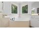 Bright bathroom features a soaking tub beneath two windows offering wooded views at 3335 Maple Terrace Dr, Suwanee, GA 30024