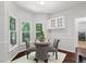 Breakfast nook with bright windows with table set with four gray upholstered chairs and dark hardwood floors at 3335 Maple Terrace Dr, Suwanee, GA 30024