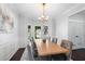 Formal dining room with a chandelier, large windows, seating for eight, and hardwood floors at 3335 Maple Terrace Dr, Suwanee, GA 30024