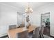 Well-lit formal dining room showcases a chandelier, wainscoting, hardwood floors, and neutral decor at 3335 Maple Terrace Dr, Suwanee, GA 30024