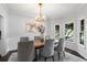 Formal dining room with a chandelier, large windows, and seating for six at 3335 Maple Terrace Dr, Suwanee, GA 30024