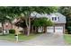 Attractive two-story brick home featuring an attached garage, lush trees, and a well-kept lawn at 3335 Maple Terrace Dr, Suwanee, GA 30024