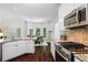 Kitchen with granite countertops, stainless steel appliances, and view to breakfast nook and outdoor greenery at 3335 Maple Terrace Dr, Suwanee, GA 30024