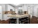 Open concept kitchen with granite countertops, stainless steel appliances, breakfast bar, and dark hardwood floors at 3335 Maple Terrace Dr, Suwanee, GA 30024