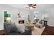 Sunlit living room with fireplace, hardwood floors, plush seating, and seamless flow to dining area at 3335 Maple Terrace Dr, Suwanee, GA 30024