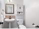 Cozy powder room with pedestal sink, tiled backsplash, decorative mirror, and storage at 3335 Maple Terrace Dr, Suwanee, GA 30024