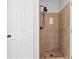 This bathroom features a beautifully tiled shower with modern fixtures and convenient storage at 3335 Maple Terrace Dr, Suwanee, GA 30024