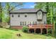 Back of the home with a cozy deck that overlooks the lawn and mature trees at 71 Anita Se Pl, Mableton, GA 30126