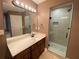 Bathroom with a wood vanity, quartz counters, and glass shower enclosure at 71 Anita Se Pl, Mableton, GA 30126