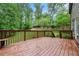 Enjoy outdoor living on this wood deck with a built-in bench surrounded by lush greenery at 71 Anita Se Pl, Mableton, GA 30126