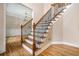 Elegant staircase with dark metal railing and wood steps leading into the house on light hardwood flooring at 71 Anita Se Pl, Mableton, GA 30126