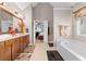 Bathroom featuring double sinks, a soaking tub, and an open view to the bedroom at 1070 Cureton Dr, Austell, GA 30106