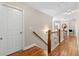 Upstairs hallway with wood floors, wooden railing, white walls and bright natural light at 1070 Cureton Dr, Austell, GA 30106