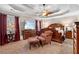 Spacious primary bedroom with tray ceilings, a ceiling fan, warm carpet and decorative furniture at 1070 Cureton Dr, Austell, GA 30106