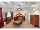 Large primary bedroom with tray ceilings, ceiling fan, and luxurious furniture at 1070 Cureton Dr, Austell, GA 30106