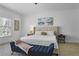Bright bedroom featuring a large bed with tufted headboard and a cozy blue bench at 1226 Goodwin Ne Rd, Atlanta, GA 30324
