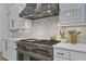 Kitchen with white cabinetry, marble backsplash, and stainless steel oven range at 1226 Goodwin Ne Rd, Atlanta, GA 30324