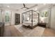This main bedroom features a four-poster bed, wood floors, a ceiling fan, and a large window with natural light at 1226 Goodwin Ne Rd, Atlanta, GA 30324