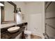 Powder room with dark granite countertop, stone sink bowl, decorative mirror, and toilet at 1226 Goodwin Ne Rd, Atlanta, GA 30324