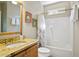 Bathroom vanity with granite countertop, framed mirror, and tub with shower at 439 Lake Point Trce, Canton, GA 30114