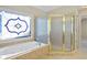Bathroom with large tub and frosted glass shower, accented by a stained-glass window at 439 Lake Point Trce, Canton, GA 30114