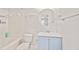 Cozy bathroom featuring a modern circular mirror, blue vanity, and shower over tub at 4420 Thorngate Ln, Acworth, GA 30101
