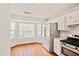 Efficient kitchen showcasing stainless steel appliances, wooden floors and bay window at 4420 Thorngate Ln, Acworth, GA 30101
