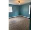Carpeted bedroom featuring a window for natural light and blue walls at 1895 Thomasville Se Dr, Atlanta, GA 30315