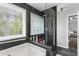 Bathroom with a combination tub and shower, featuring stone accents and natural light at 2077 Alcovy Trace Way, Lawrenceville, GA 30045
