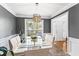 Dining room with a glass table, white chairs, modern chandelier, and light from the window at 2077 Alcovy Trace Way, Lawrenceville, GA 30045