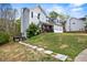 Classic two-story home with attached garage, green lawn, landscaping, and stone walkway up the hill at 2077 Alcovy Trace Way, Lawrenceville, GA 30045