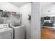 A functional laundry room with a washer and dryer, complemented by storage shelves and a view into the living space at 2077 Alcovy Trace Way, Lawrenceville, GA 30045