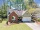 Charming home with brick and light green siding, featuring a two-car garage and manicured lawn at 4009 Glenlake Nw Trce, Kennesaw, GA 30144