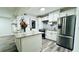 Modern kitchen featuring stainless steel appliances, bright white cabinetry and backsplash, with an island and wood-style flooring at 1382 Branch Dr, Tucker, GA 30084