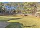Spacious backyard with lush green grass, a white fence, and a swing set at 3405 River Ridge, Stockbridge, GA 30281