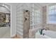 Bathroom with a glass block shower, marble tile, and a soaking tub at 3405 River Ridge, Stockbridge, GA 30281