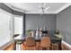 Elegant dining room featuring dark gray walls, sleek lighting and seating for six at 3405 River Ridge, Stockbridge, GA 30281