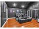 A home theater room with tiered seating, dark walls, and wood floors for an immersive viewing experience at 3405 River Ridge, Stockbridge, GA 30281