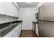 Kitchen featuring stainless steel appliances, granite countertops, white cabinets, and updated finishes at 1150 Collier Nw Rd # F11, Atlanta, GA 30318