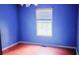 Bright bedroom featuring hardwood floors, a window, and vibrant blue walls at 4443 Whitt Mill Nw Rd, Acworth, GA 30101