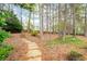 Lush backyard with stone paver path, mature trees, and privacy fence, creating a serene outdoor space at 111 Glen Trl, Woodstock, GA 30188