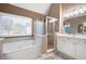 Bright bathroom featuring a large tub and glass-enclosed shower at 111 Glen Trl, Woodstock, GA 30188