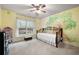 Bright bedroom with playful tree mural, large window with natural light, and unique wrought iron bedframe at 111 Glen Trl, Woodstock, GA 30188