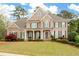 Charming two-story brick home boasts a well-manicured lawn, shutters, and welcoming front porch at 111 Glen Trl, Woodstock, GA 30188
