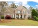 Charming two-story brick home boasts a well-manicured lawn, shutters, and welcoming front porch at 111 Glen Trl, Woodstock, GA 30188