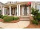 Inviting front porch with classic brick steps, white columns, and manicured landscaping at 111 Glen Trl, Woodstock, GA 30188