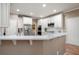 Modern kitchen with white cabinets, quartz countertops, stainless steel appliances, and a breakfast bar overlooking the dining area at 111 Glen Trl, Woodstock, GA 30188