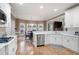 Well-lit kitchen with stainless steel appliances, white cabinets, and a view of the dining area and living room at 111 Glen Trl, Woodstock, GA 30188